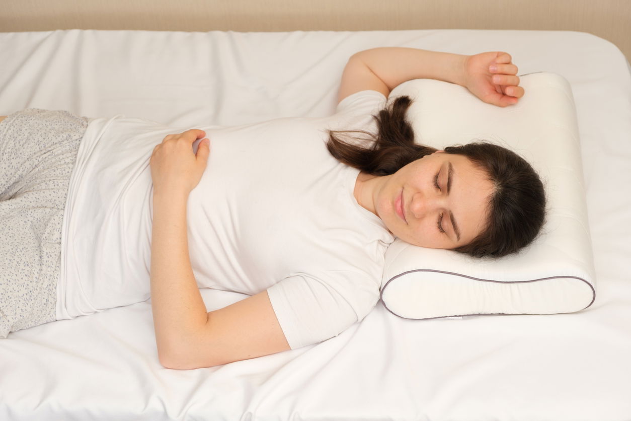 A woman is sleeping soundly, lying on her back. Demonstrates back sleeping position.