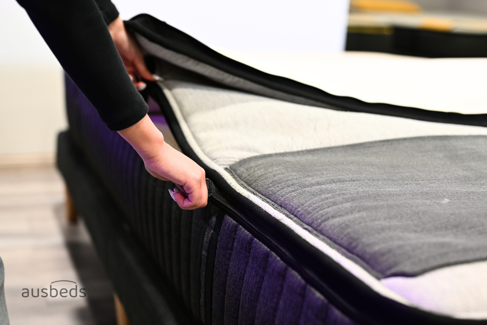 Hands unzipping an Ausbeds mattress cover
